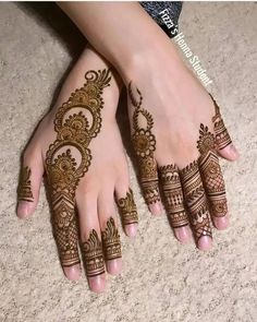 two hands with henna tattoos on them