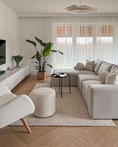 a living room filled with furniture and a flat screen tv on top of a wooden floor