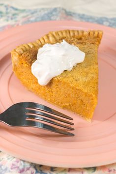 a piece of pie sitting on top of a pink plate with a fork next to it