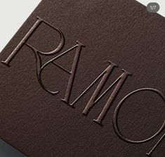 a close up of the letters on a brown paper with silver foil and black lettering