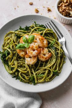 a white plate topped with pasta and shrimp