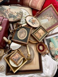 there are many pictures and paintings on the table together, including one with a red purse