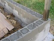 a cement planter sitting in the middle of a yard next to a wooden pole