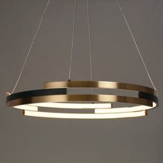 a circular light fixture hanging from the ceiling in a room with grey walls and flooring