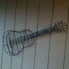 a metal guitar hanging on the side of a wall