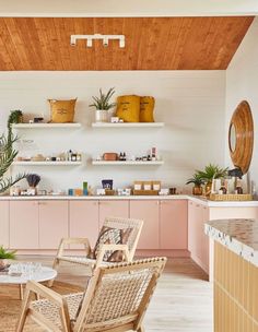 a living room filled with furniture and lots of shelves on the wall next to a kitchen