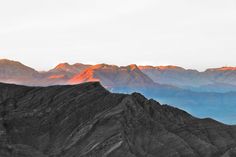 the mountains are covered in orange and blue hues