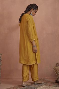 Yellow chanderi kurta with floral hand embroidered yoke and side pockets. Comes with cotton silk pant and a cotton slip.
Components: 3
Pattern: Hand embroidered
Type Of Work: Floral
Neckline: Round
Sleeve Type: Puffed Sleeves
Fabric: Kurta: Chanderi, Pant: Cotton silk, Slip: Cotton
Color: Yellow
Other Details: 
Length:
Kurta: 42 inches
Pant: 38 inches
Closure: Kurta - Front buttons
Occasion: Mehendi and Haldi - Aza Fashions Linen Sets With Chikankari Embroidery In Straight Kurta Style, Festive Linen Dupatta With Zari Work, Traditional Linen Sets For Diwali, Diwali Linen Dupatta, Unstitched Linen Straight Kurta, Unstitched Linen Kurta For Eid, Festive Unstitched Linen Kurta, Designer Linen Kurta For Eid, Designer Linen Straight Kurta