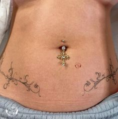 a woman's stomach with a cross tattoo on it