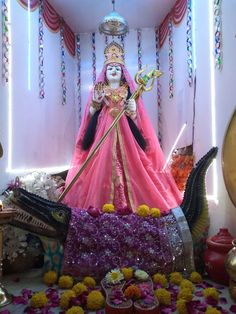 a statue of the hindu god ganesh is surrounded by flowers and other decor items