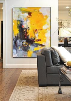 a living room filled with furniture and a large painting on the wall above it's couch