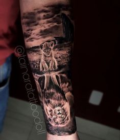 a man's arm with an image of two lions and a cat on it