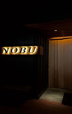 the door is illuminated by two lights in front of it that reads, nobu