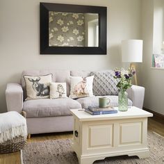 a living room filled with furniture and a large mirror on the wall above it's coffee table