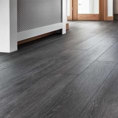 an empty room with wood flooring and white radiator on the wall in front of it