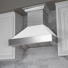 a stainless steel range hood mounted on the side of a kitchen wall with white cabinets