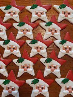 decorated cookies with santa claus faces and holly leaves on wooden table top, ready to be eaten