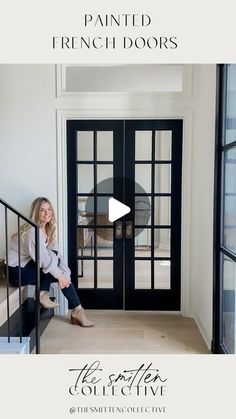 a woman sitting on the steps in front of a black door with glass panels and french doors