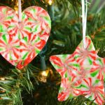 two heart shaped ornaments hanging from a christmas tree