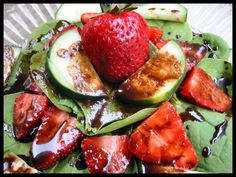 a salad with strawberries, cucumbers and other fruits on it is shown