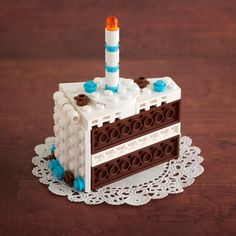 the cake is made out of legos and has a candle on top of it