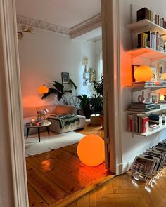 a living room filled with furniture and bookshelves next to a wall mounted book shelf