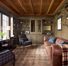 a living room with couches, chairs and bookshelves on the wall in it