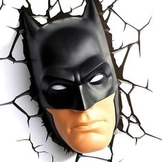 a batman mask on top of a cracked wall