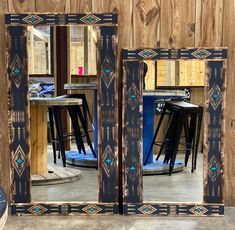 a pair of mirrors sitting on top of a wooden floor next to a table and stools