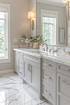 a large bathroom with two sinks and marble counter tops in front of three windows on either side of the bathtub