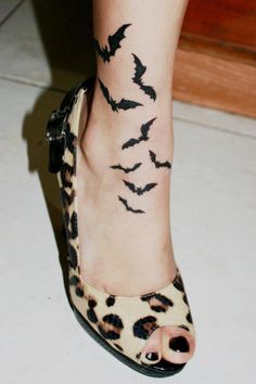 a woman's foot with bats on it and the caption reads, tattoo by tom raven