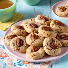 a plate full of cookies with pecans on top