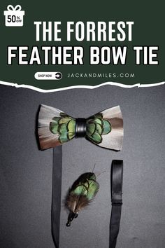 A feathered bow tie and matching lapel pin displayed on a dark surface. The bow tie features layered green, brown, and white feathers with a black leather band in the center. The lapel pin has a similar green and brown feather design with a metal clasp. Feather Bow Ties, Board Room, Groom Ties, Bow Ties, Wooden Box, In The Woods, Wooden Boxes, Bow Tie, Special Events