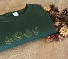 Handmade embroidered Autumn leaves design onto unisex sweatshirt ✯PRODUCT DETAILS✯ Please note: The photos taken are only indicative every single top is completely handmade therefore all unique! ✯ECO SWEATSHIRT✯  Currently only available in Size Small, Medium and Large  The eco sustainable sweatshirt is made to a very high quality, it's crafted from premium organic and recycled fabrics.  It's 350gsm (so nice and thick) and the inside is a super soft brushed fabric, so will keep you nice and warm Fall Custom Embroidery Sweatshirt Gift, Custom Embroidery Sweatshirt As Fall Gift, Fall Gift Sweatshirt With Embroidered Logo, Fall Tops With Embroidered Logo As Gift, Embroidered Green Sweatshirt For Fall, Fall Gift Sweatshirt With Embroidered Graphics, Fall Sweatshirt With Embroidered Graphics For Gift, Embroidered Tops As Fall Gifts, Fall Tops With Embroidered Graphics For Gift