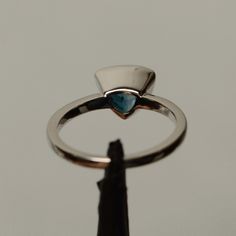 It is a real London blue topaz ring. The main stone is 8 mm*8mm triangular. The basic metal is sterling silver and plated with rhodium. To change the metal to a solid gold (white/rose) or platinum is also available, please ask for a quotation if you want. You can also go to my shop Home for more elegant rings: https://www.etsy.com/shop/godjewelry?ref=hdr_shop_menu Topaz is November birthstone. More topaz rings: https://www.etsy.com/shop/godjewelry?ref=hdr_shop_menu&section_id=20715039 Custom Trillion Cut Sapphire Anniversary Ring, Blue Topaz Ring With Bezel Setting For Promise, Modern White Gold Trillion Cut Ring, Modern Silver Trillion Cut Ring, Silver Sapphire Trillion Cut Promise Ring, Silver Trillion Cut Sapphire Promise Ring, Blue Trillion Cut Sterling Silver Ring, Modern Blue Topaz Jewelry With Bezel Setting, Modern Trillion Cut Promise Ring