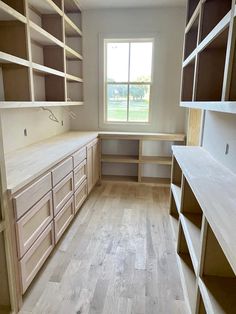 an empty room with lots of shelves and cupboards in the corner, along with a window