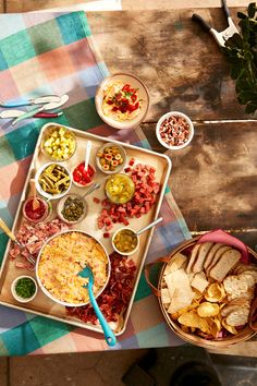 a table topped with plates and bowls filled with different types of food next to utensils