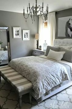 a bedroom with gray walls and white bedding