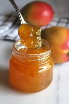 a spoon full of honey sitting next to some fruit