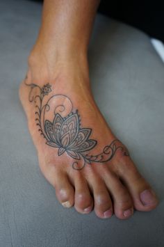 a woman's foot with a flower tattoo on it