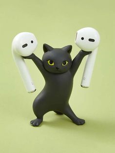 a black cat figurine holding two white objects