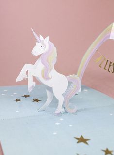 a paper cut out of a unicorn on top of a blue box with gold stars