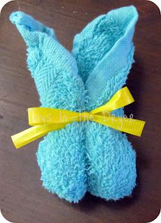 a pair of blue mittens with yellow ribbon tied around them on a wooden table