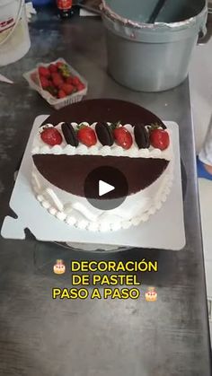 a cake with chocolate and strawberries on it sitting on top of a table next to a pan