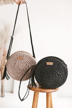 two round straw bags sitting on top of a wooden stool