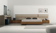 a modern bedroom with white walls and wood furniture