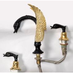 two black and gold faucets with wings on them