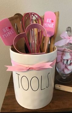 a white bucket filled with pink utensils on top of a wooden table