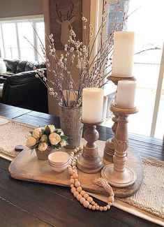 a table with candles, flowers and beads on it in front of a door way