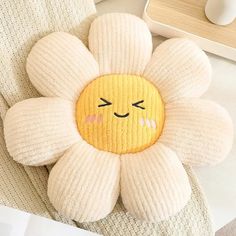 a flower shaped pillow sitting on top of a couch